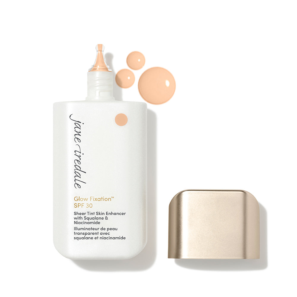 Geöffnete Flasche des jane iredale Glow Fixation SPF 30 mit Verschluss und einem Tropfen der Farbtextur auf weißem Hintergrund.